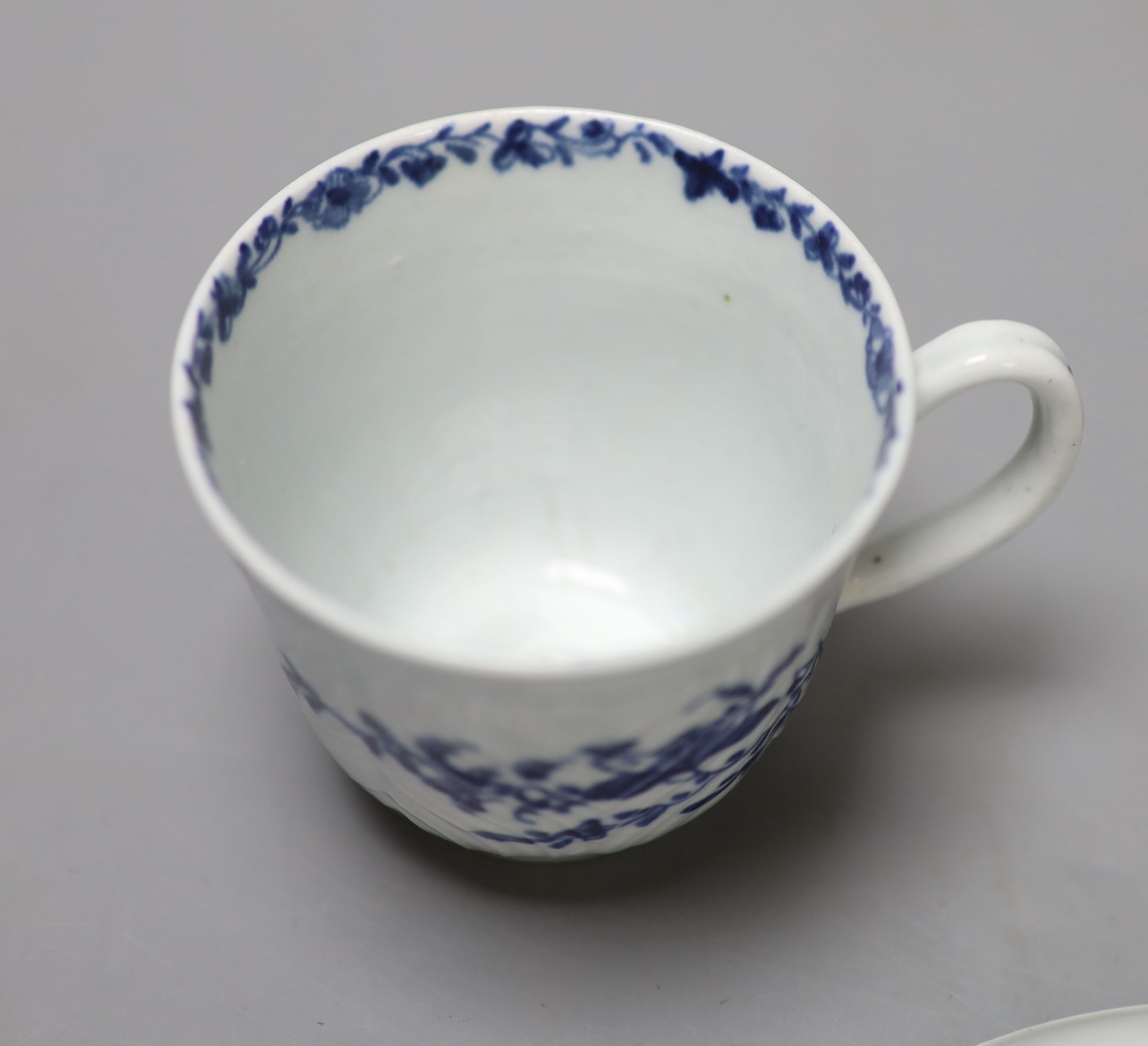 An 18th century Worcester feather mould floral coffee cup and saucer, workmans marks, diameter 11.5cm